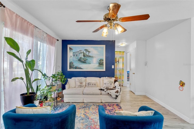 living room with ceiling fan and light hardwood / wood-style flooring