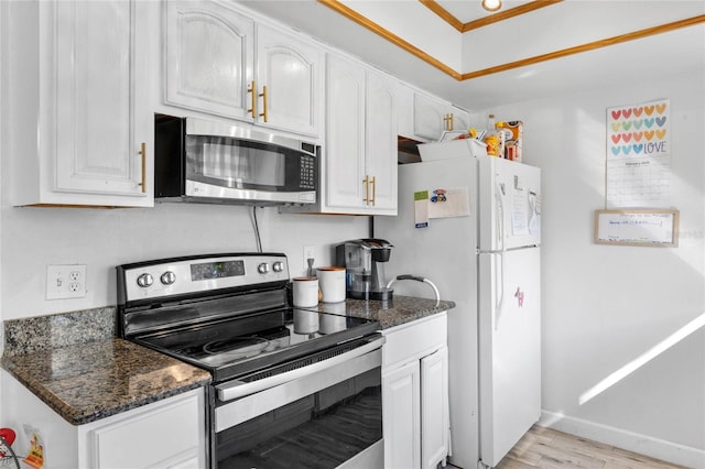 kitchen with white cabinetry, appliances with stainless steel finishes, dark stone countertops, and light hardwood / wood-style flooring