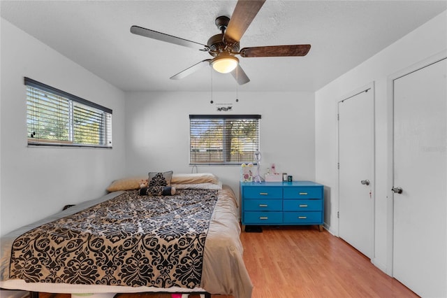 bedroom featuring a textured ceiling, light hardwood / wood-style floors, and ceiling fan