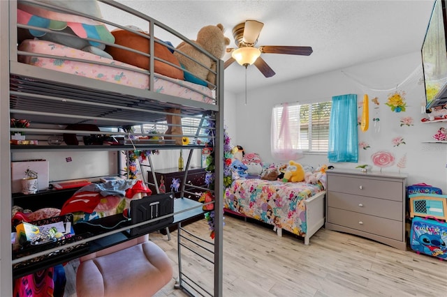 bedroom with ceiling fan, a textured ceiling, and light wood-type flooring