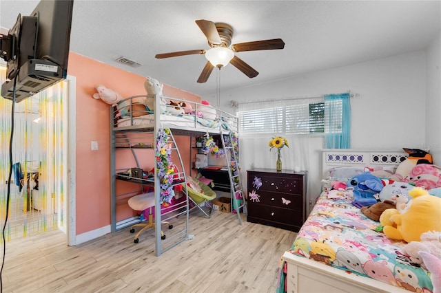 bedroom with ceiling fan, a textured ceiling, and light hardwood / wood-style floors