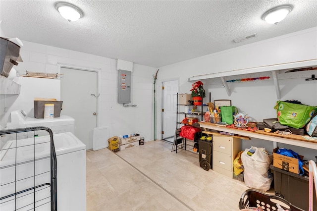 clothes washing area featuring electric panel, washer and dryer, and a textured ceiling