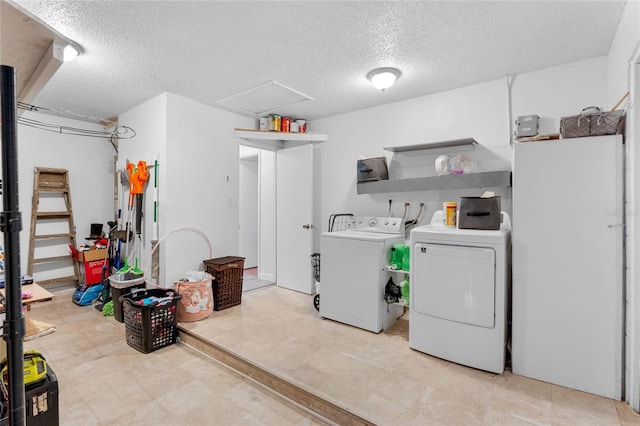 washroom with washing machine and dryer and a textured ceiling