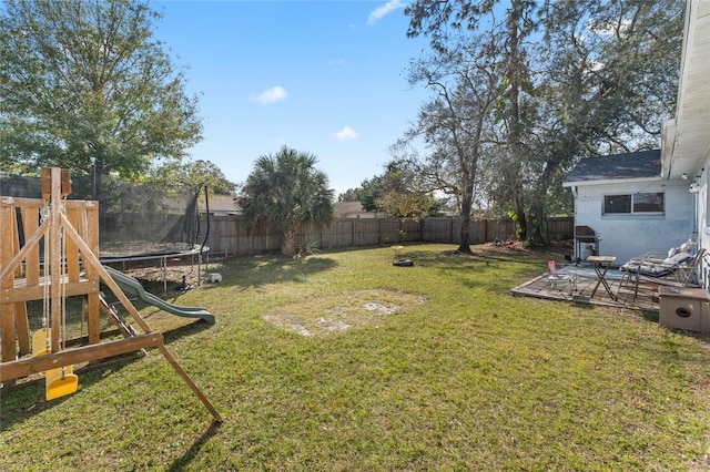 view of yard with a trampoline and a playground