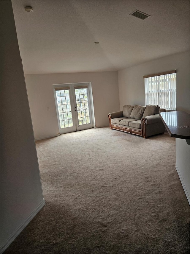 unfurnished living room with carpet, visible vents, french doors, and baseboards