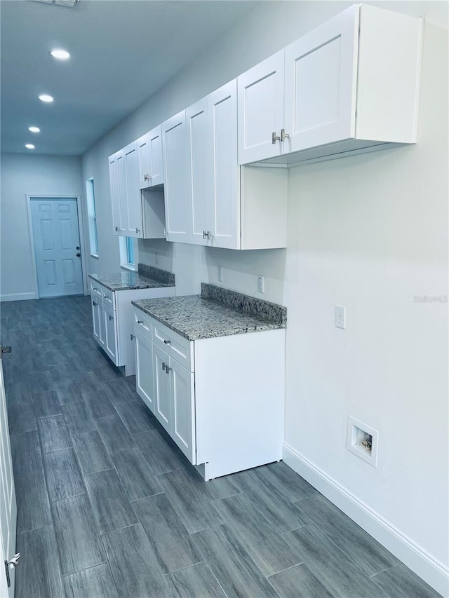 kitchen featuring baseboards, white cabinets, light stone counters, wood finish floors, and recessed lighting