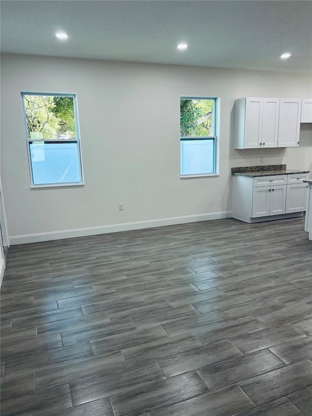 kitchen with baseboards, dark countertops, dark wood-style flooring, white cabinetry, and recessed lighting