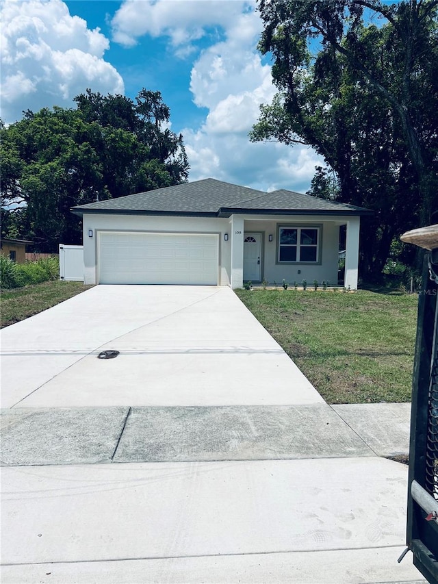 1015 25th St, Orlando, FL 32805 - view of front facade featuring concrete driveway, an attached garage, stucco siding, and a front yard