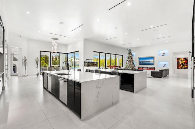 kitchen featuring a large island, sink, light stone counters, and plenty of natural light