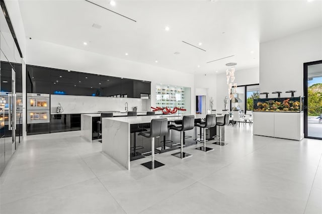 kitchen featuring a spacious island, a kitchen bar, and tasteful backsplash