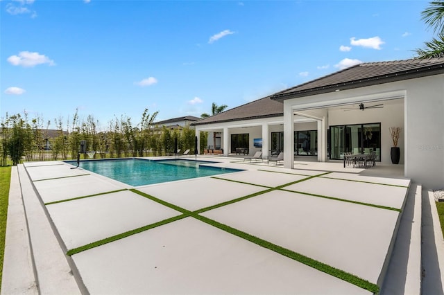 view of swimming pool featuring ceiling fan and a patio area