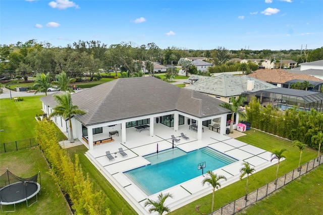 view of swimming pool featuring a trampoline, a yard, and a patio