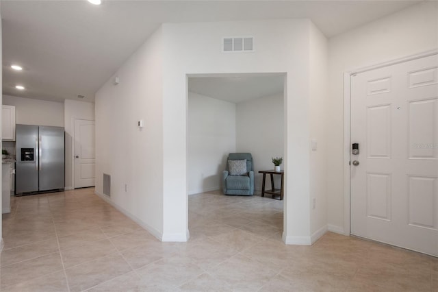 entryway featuring light tile patterned floors, baseboards, and visible vents