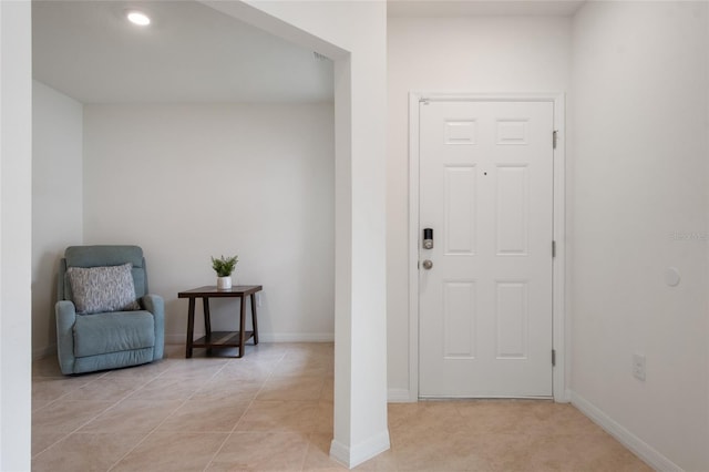 foyer entrance featuring light tile patterned floors and baseboards