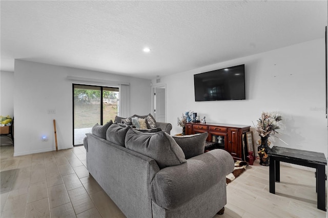 living room with light hardwood / wood-style flooring and a textured ceiling