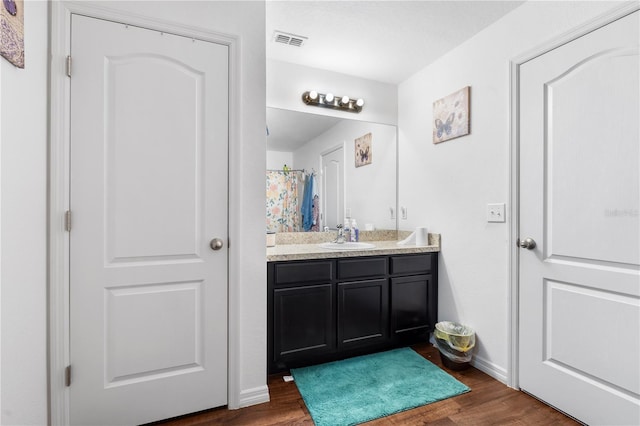 bathroom featuring vanity, curtained shower, and wood-type flooring