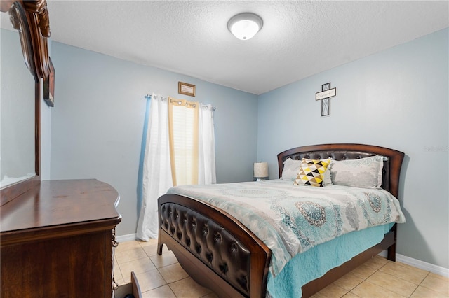 bedroom featuring light tile patterned floors and a textured ceiling