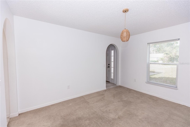 carpeted spare room with a textured ceiling