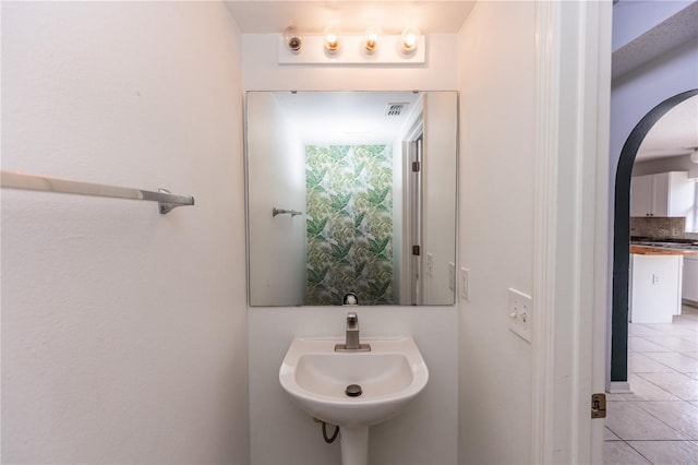 bathroom with sink, tile patterned floors, and decorative backsplash