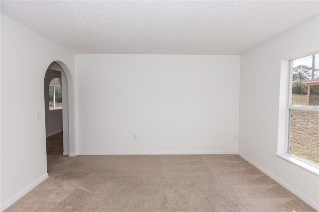 carpeted spare room featuring a textured ceiling