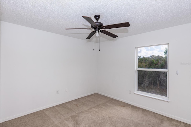 unfurnished room with ceiling fan, light carpet, and a textured ceiling