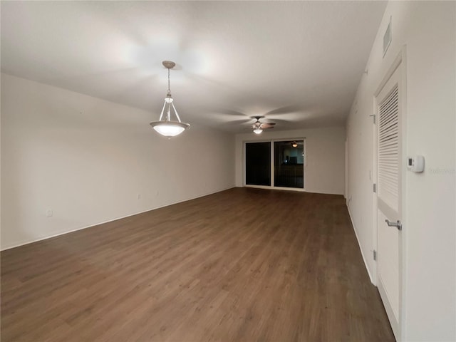 unfurnished room featuring dark wood-type flooring and ceiling fan