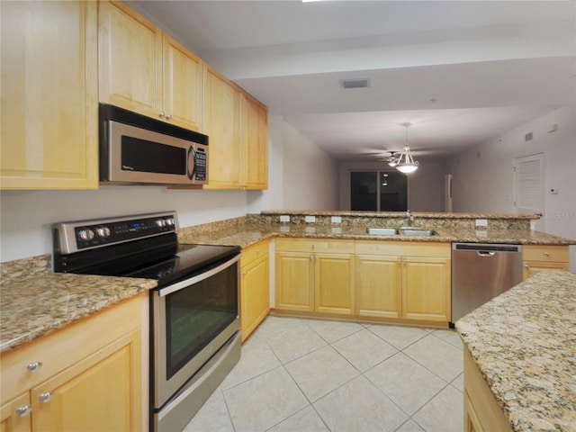 kitchen with appliances with stainless steel finishes, sink, light brown cabinets, and kitchen peninsula