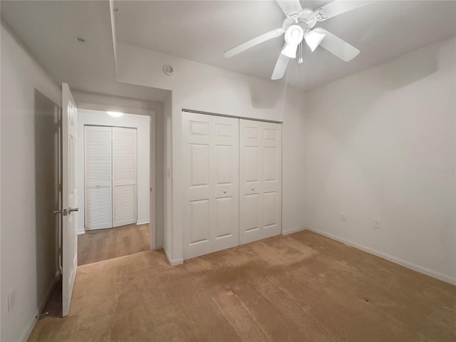 unfurnished bedroom with ceiling fan, carpet, and a closet