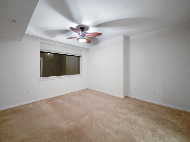 spare room with ceiling fan and light carpet