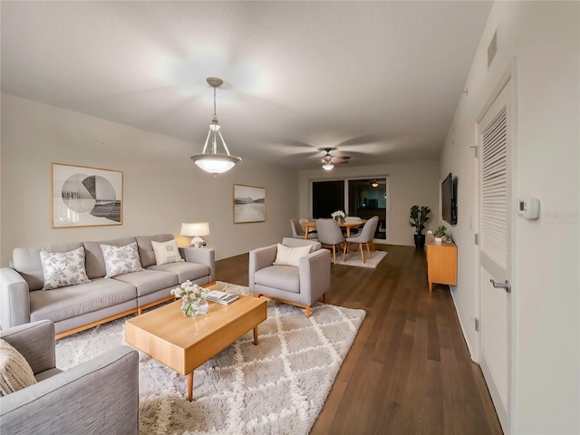 living room with ceiling fan and dark hardwood / wood-style floors