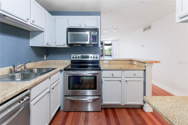 kitchen featuring sink, appliances with stainless steel finishes, white cabinetry, dark hardwood / wood-style floors, and kitchen peninsula