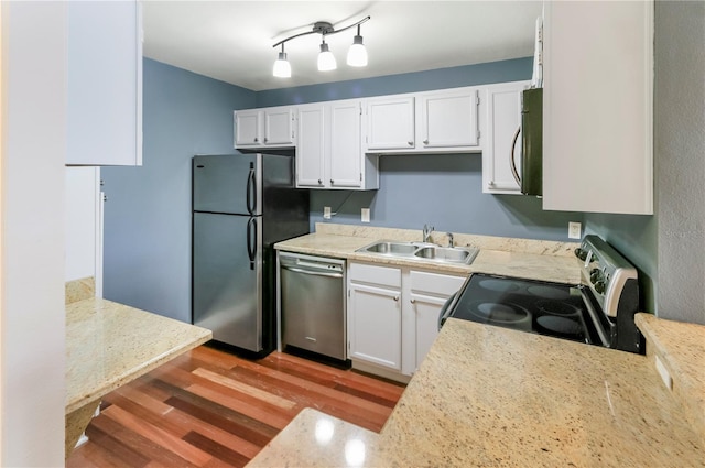 kitchen featuring white cabinetry, sink, stainless steel appliances, and light hardwood / wood-style floors