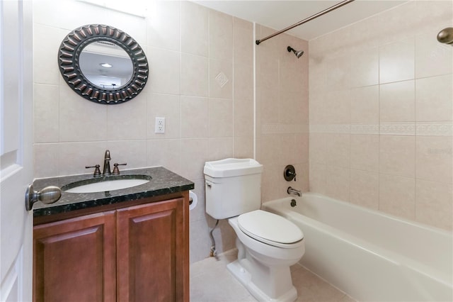 full bathroom with tiled shower / bath, toilet, tile patterned flooring, and tile walls