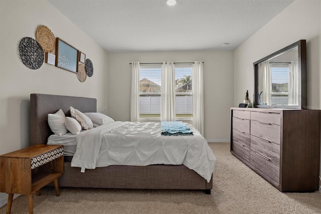 bedroom with light carpet and a textured ceiling