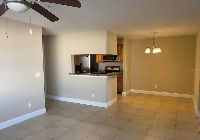 kitchen featuring appliances with stainless steel finishes, ceiling fan with notable chandelier, pendant lighting, light tile patterned floors, and kitchen peninsula