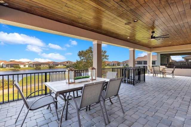 view of patio with a water view and ceiling fan