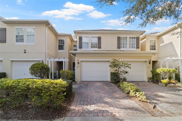 3257 Villa Strada Way, Orlando, FL 32835 - townhome / multi-family property featuring an attached garage, stucco siding, and decorative driveway