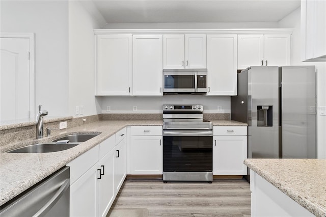 kitchen featuring white cabinetry, appliances with stainless steel finishes, sink, and light wood-type flooring