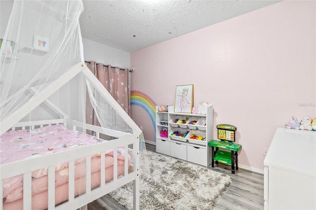 bedroom with a textured ceiling and light wood-type flooring