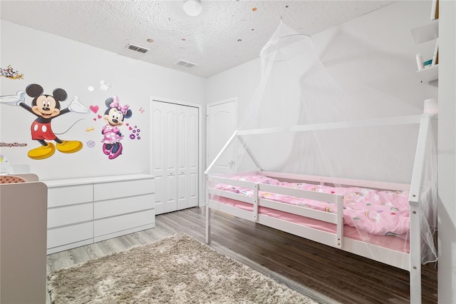 bedroom featuring a closet, light hardwood / wood-style floors, and a textured ceiling