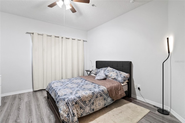 bedroom featuring hardwood / wood-style flooring, ceiling fan, and a textured ceiling