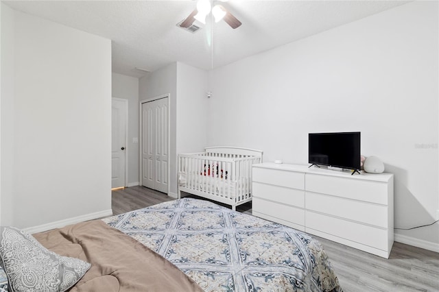 bedroom with hardwood / wood-style flooring, a textured ceiling, a closet, and ceiling fan