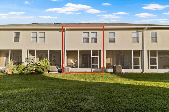 back of property with central AC, a lawn, and a sunroom