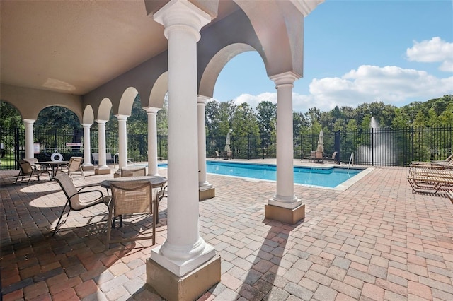 view of swimming pool with a patio and a water view