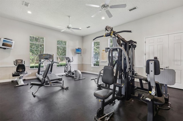 gym featuring ceiling fan and a textured ceiling