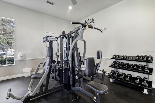 workout room featuring ceiling fan, a textured ceiling, and a wealth of natural light