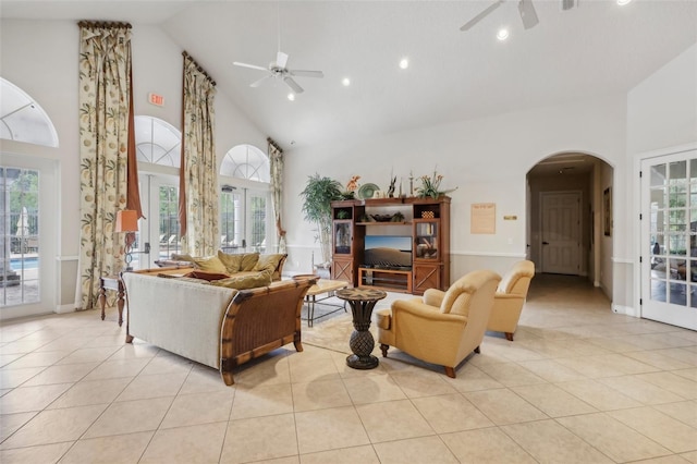 living room with light tile patterned floors, plenty of natural light, high vaulted ceiling, and ceiling fan