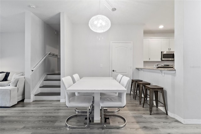 3257 Villa Strada Way, Orlando, FL 32835 - dining area with recessed lighting, light wood-type flooring, baseboards, stairs, and a notable chandelier
