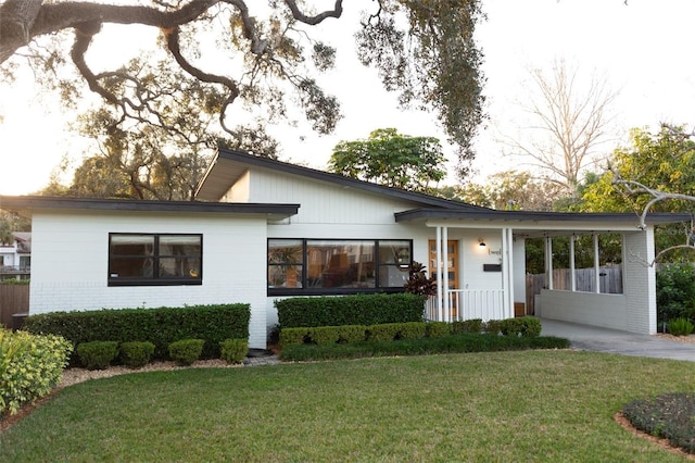 view of front of property featuring a carport and a front lawn