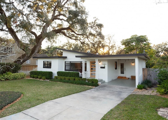 view of front of home with a carport and a lawn